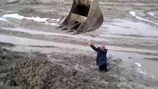 Опитен багерист помага на човек заседнал в калта - Videoclip.bg